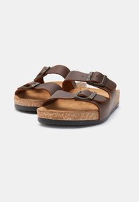 Smeđe kožne sandale s dva podesiva remena, srebrnim kopčama, plitvim uloškom od pluta i teksturiranom crnom gumenom potplatom.