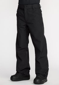 Pantalons de neige noirs imperméables à coupe décontractée, avec un devant plat, une fermeture à bouton et à glissière, et des poches. Tissu texturé.