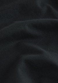 Black fabric with a smooth texture, featuring subtle diagonal ribbing. The material appears soft and drapes naturally.