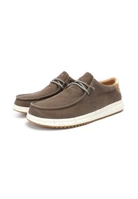 Brown canvas shoes with a rounded toe, white speckled rubber sole, and light brown interior. Gray laces and subtle branding detail.