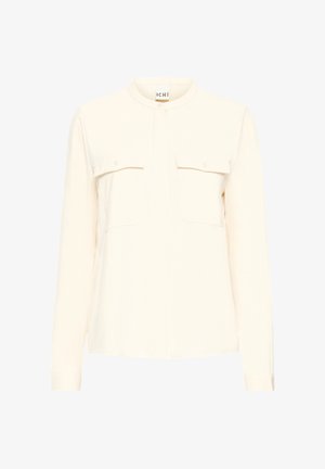 Šviesiai grietinėlės spalvos mygtukų marškiniai su dviem krūtinės kišenėmis, apvaliu apykakle, ilgomis rankovėmis ir minkšta tekstūra. Paprastos, tiesios kirpimo dizainas.