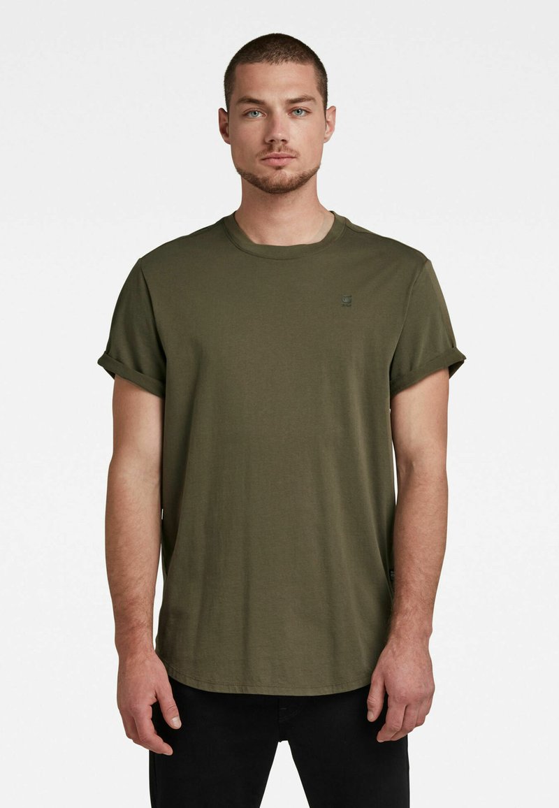 Camiseta de algodón verde oliva con mangas cortas enrolladas y cuello redondo. Presenta un pequeño logotipo en el pecho y un dobladillo recto.