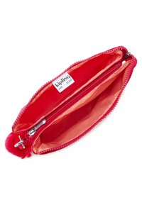 Custodia rossa con zip e un'esterno morbido, con un interno vivace e un charm a pom-pom. L'etichetta riporta "kipling" con "LIVE LIGHT" sotto.