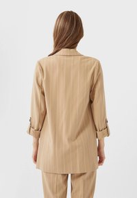 Stradivarius Pitkä takki - beige