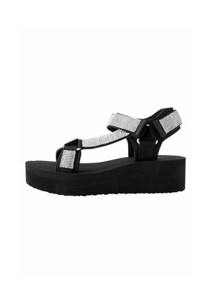 Sandali platform neri con suola texturizzata, caratterizzati da ampie fascette decorate con brillanti strass per un tocco di eleganza.
