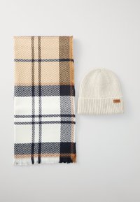 Sciarpa a quadri in beige, bianco e blu navy, con bordi frangiati; berretto a coste crema con una piccola etichetta in pelle.