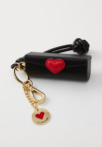 Black keychain holder made of textured material, featuring a red heart accent, gold hardware, and a metal tag with a red heart design.