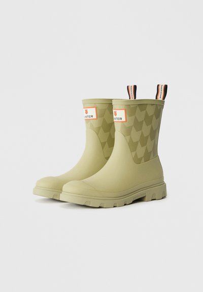 Khaki gumijasti škornji za dež z geometrijskim teksturiranim vzorcem, označenim trakom in ročaji v kontrastnih barvah za enostavno obuvanje.