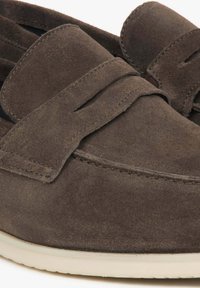 Bruine nubuck instappers met een gestikt ontwerp en een platte, lichtgekleurde rubbersole. Beschikt over een klassieke ronde neus en een decoratief riempje.