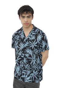 Camicia a maniche corte con sfondo nero e modelli di foglie tropicali azzurro chiaro. Il materiale sembra leggero e traspirante.