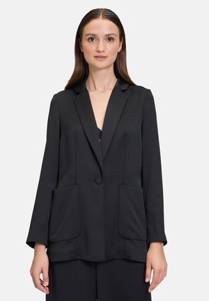 Schwarzer Blazer aus glattem Stoff, mit einem einzelnen Knopfverschluss, zwei großen Fronttaschen und einem Reversdesign.