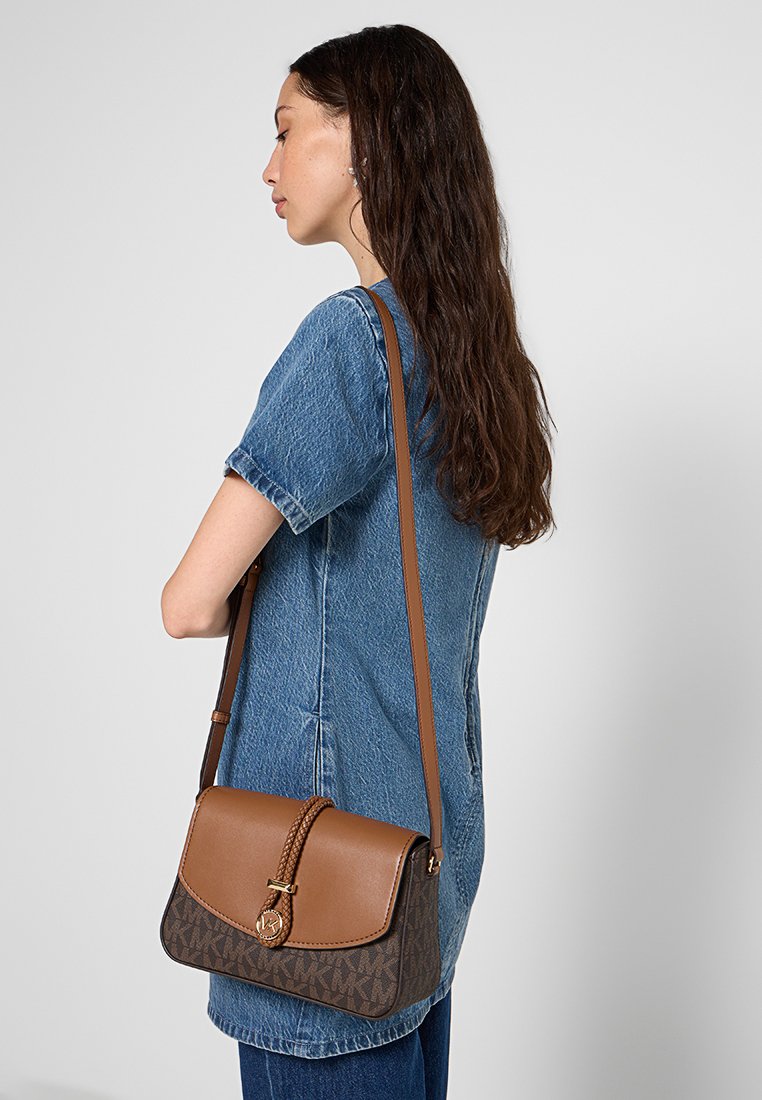 Braune Leder-Crossbody-Tasche mit einem geflochtenen Riemen, die einen gemusterten unteren Bereich und goldene Hardware-Akzente aufweist.