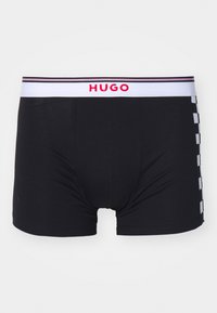 Boxeri negri cu o talie albă pe care este inscripționat "HUGO" în roșu. Pe latură se află un model carourile cu pătrate alb-negre contrastante.