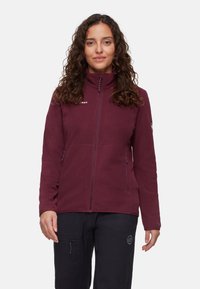 Burgundowy polarowy kurtka z wysokim kołnierzem, zamkiem błyskawicznym z przodu i kieszeniami bocznymi. Teksturowany materiał z gładkim wykończeniem i logo na klatce piersiowej.