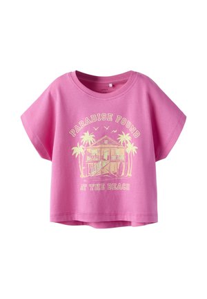 Camiseta rosa de manga corta con una casa de playa, palmeras, pájaros y el texto "Paraíso Encontrado en la Playa" impreso en amarillo claro.