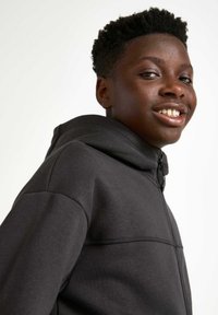 Dunkelgrauer Reißverschluss-Hoodie mit hohem Kragen, aus weichem Stoff. Verfügt über eine gestickte Akzentlinie über der Brust und einen Reißverschluss vorne.