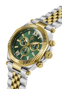 Złoty i srebrny zegarek metalowy z zieloną tarczą, z rzymskimi cyframi jako oznaczeniami, subtarczami chronografu i żłobkowaną złotą bezelą.