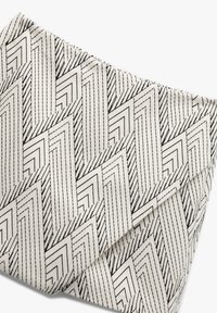 Clutch tas met een roomkleurige achtergrond met een zwart zigzag- en geometrisch patroon, textiel met een gestructureerde stof en strakke lijnen en hoeken.