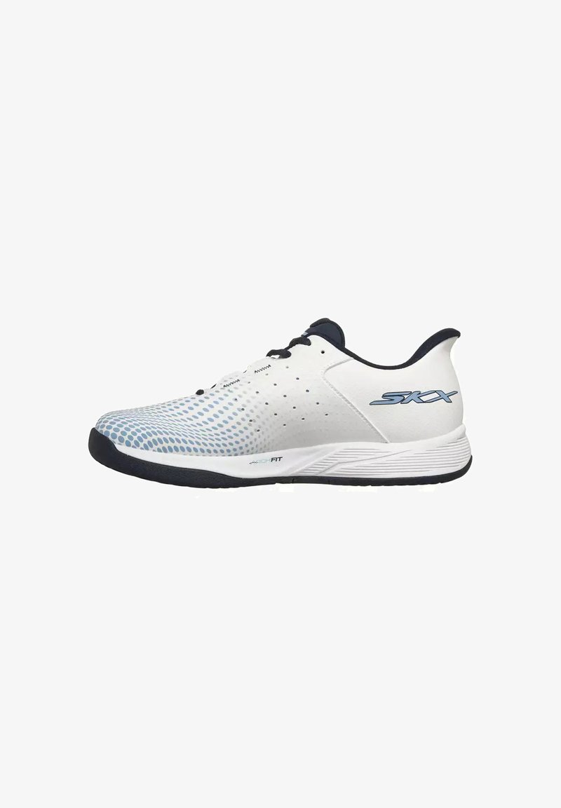Baskets athlétiques blanches avec un motif de points bleus sur la pointe, semelle noire et lacets noirs, et le logo "SKX" sur le côté du talon.