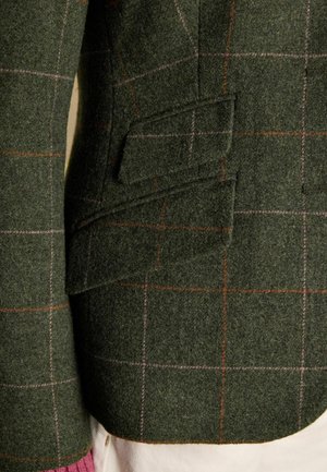 Dunkelgrüner Wollblazer mit einem karierten Muster in Orange und Pink. Verfügt über eine Seitentasche und einen strukturierten Stoff. Nahaufnahme.