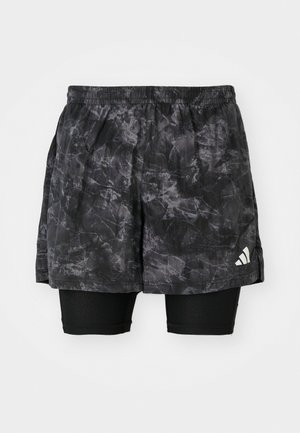 Zwarte sportshorts met een marmerpatroon en binnenste compressieshorts. Beschikt over een elastische tailleband en een klein wit logo aan de zijkant.