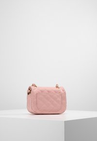 Malá růžová prošívaná kabelka se zlatými doplňky, přední kapsou a ramenním popruhem. Hladký povrch s kompaktním obdélníkovým tvarem.