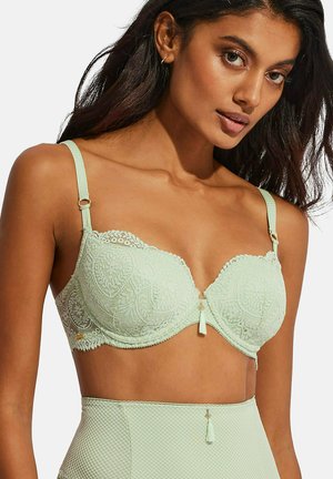 Mintgroene kanten beha met contourcups, verstelbare bandjes en decoratieve hardware. Heeft ingewikkelde bloemmotieven en een klein strikdetail.