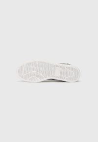 Sola do sapato com um padrão texturizado em colmeia em borracha branca, projetada para aderência e flexibilidade. Minimalista, sem marcas visíveis.