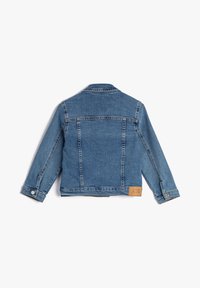 Kinderen blauwe denim jack met lange mouwen, knopenmanchetten en een klein leren label met de tekst "Koton KIDS" op de rechter onderrug.