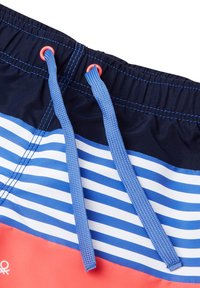 Costumi da bagno caratterizzati da strisce orizzontali blu e bianche, con una sezione inferiore corallo. Inclusi lacci blu e occhielli rossi.