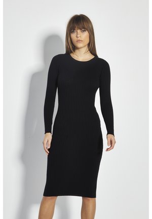 Zwarte geribbelde gebreide jurk met lange mouwen, slank silhouet en ronde halslijn. Soepele textuur, knielengte, minimale details.