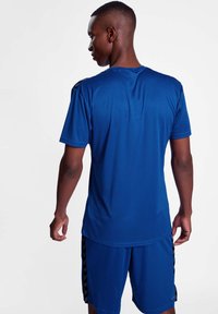 Sporty blå T-shirt med korte ærmer, glat tekstur, sideløbende striber og en afslappet pasform, parret med matchende shorts.