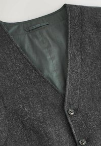 Gray textured vest with a v-neck design, featuring two buttons and a darker gray, smooth inner lining.