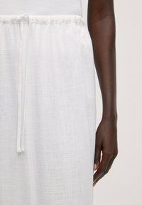 Witte linnen broek met een gestructureerde afwerking, voorzien van een elastische tailleband en een strikkoord. Slank silhouet met een ontspannen pasvorm.