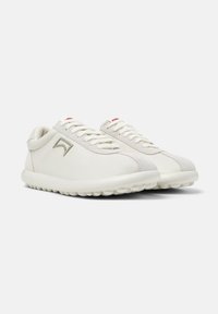 White sneakers featuring a smooth leather upper with suede accents, round toe, lace-up front, and a rubber sole with a textured grip.