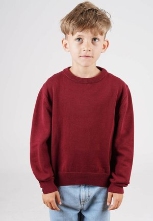 Bordeaux farvet pullover sweatshirt, rund halsudskæring, lange ærmer, blød tekstur, løs pasform. Kombineret med lyseblå denim jeans.