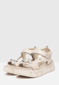 Sandali platform beige con tomaia in pelle liscia, cinturini regolabili e gemme decorative sul davanti. Suola in gomma robusta.