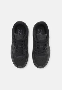 Svarta sneakers med snörning, slät syntetisk ovandel, perforerad tå och kontrasterande logotyp på tungan och sidan.