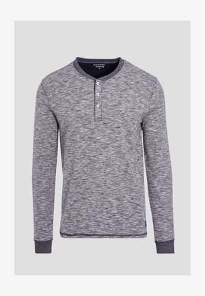 Pitkähihaisessa henley-paidassa on harmaa marlenkangas, pyöreä pääntie, kolmen napin läppä ja kontrastiväriset hihansuut.