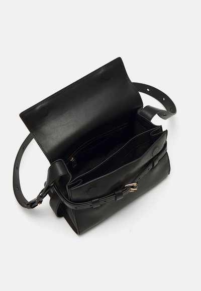 Bolsa de couro preta com um formato estruturado, fecho plano, alça ajustável e vários compartimentos interiores para organização.