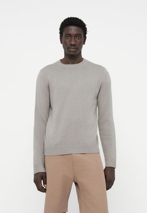 Hellgrauer Strickpullover mit rundem Halsausschnitt und gerippten Manschetten, leicht taillierte Passform, kombiniert mit beigen Shorts, glatte Textur, schlichte Optik.