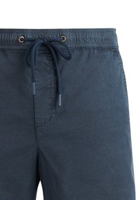 Bañador azul marino con cinturilla elástica y cordón ajustable con extremos y ojales de metal.