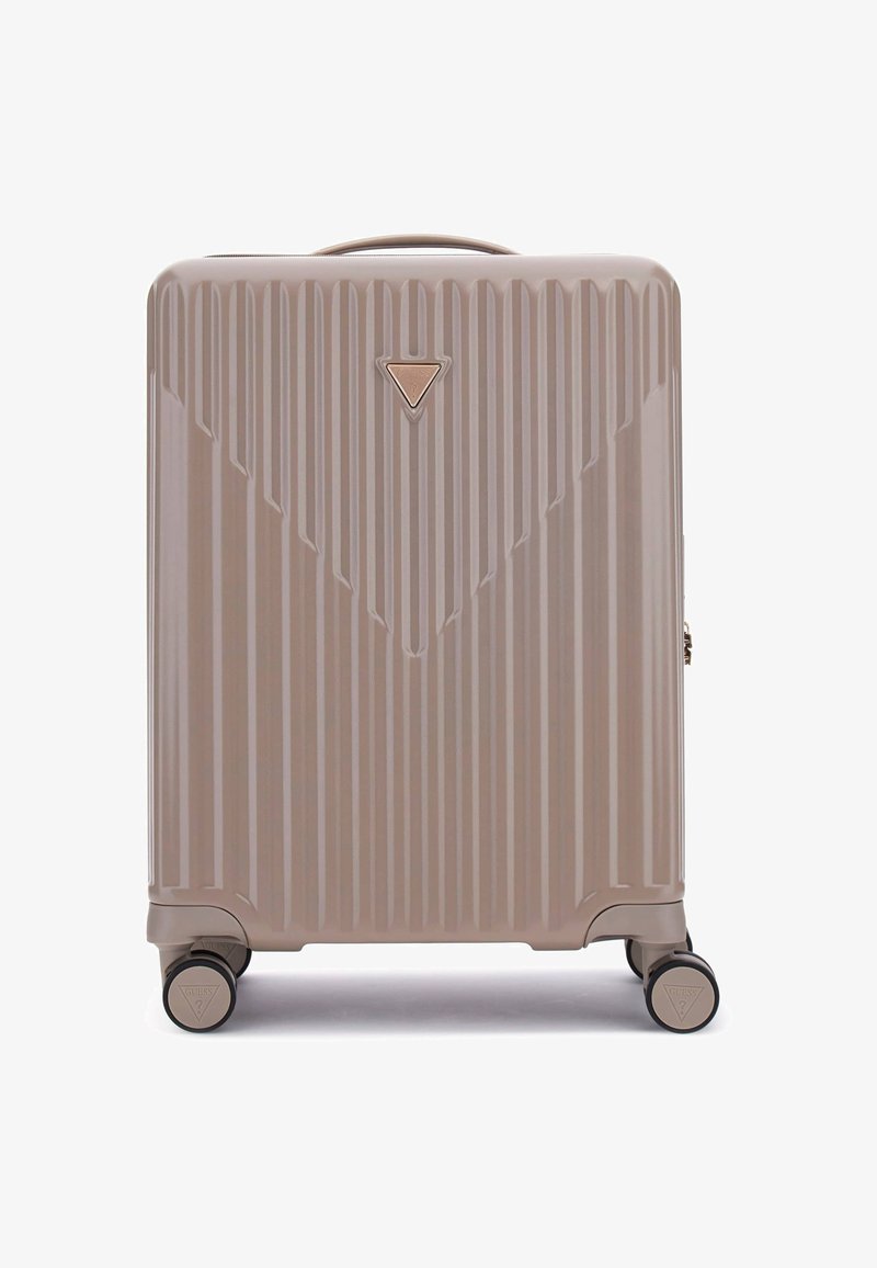 Valise rigide de couleur beige clair. Présente une texture à stries verticales, un logo triangulaire à l'avant et quatre roulettes noires.