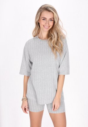 Top corto grigio a coste con scollo rotondo, abbinato a pantaloni corti coordinati e testurizzati. Tessuto leggero. Silhouette comoda e rilassata.