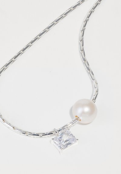 Silver kedja halsband med en rund vit pärla och en rektangulär klar ädelsten, med en polerad yta och symmetrisk design.