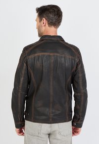 Schwarze Lederjacke mit strukturierter Oberfläche, ausgestattet mit Kontrastnähten und einer taillierten Passform, die einen klassischen Kragen und Knopfdetails zeigt.