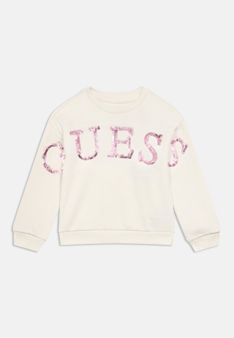 Κρεμ μακρυμάνικη μπλούζα με ροζ πούλιες που σχηματίζουν τη λέξη "GUESS" στο στήθος και τα μανίκια.