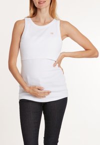 Wit katoenen zwangerschaps tanktop met een aansluitend ontwerp, geribbelde textuur en een ronde halslijn met een klein logo op de borst.