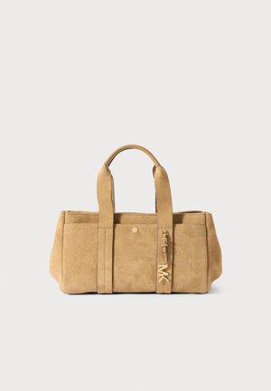 Sac à main rectangulaire en daim fauve avec deux poignées et un petit porte-bonheur en métal suspendu.