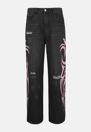 Jean noir à larges jambes avec des patchs usés et des motifs de flammes tribales roses sur les cuisses extérieures et les genoux.